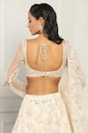 Shop_MeenaGurnam_Ivory Net Embroidery Beads Asymmetric Neck Floral Sequin Bridal Lehenga Set _at_Aza_Fashions