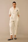 Ampm Ivory Linen, Faux Leather Brooches, Embroidery Placed Flower Pattern Jumpsuit Online at Aza Fashions Ampm_Ivory Linen, Faux Leather Brooches, Embroidery Placed Flower Pattern Jumpsuit_Online_at_Aza_Fashions