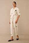 Shop Ampm Ivory Linen, Faux Leather Brooches, Embroidery Placed Flower Pattern Jumpsuit Online at Aza Fashions Shop_Ampm_Ivory Linen, Faux Leather Brooches, Embroidery Placed Flower Pattern Jumpsuit_Online_at_Aza_Fashions