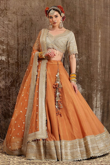 Photo of light orange net layered lehenga with sleeveless blouse