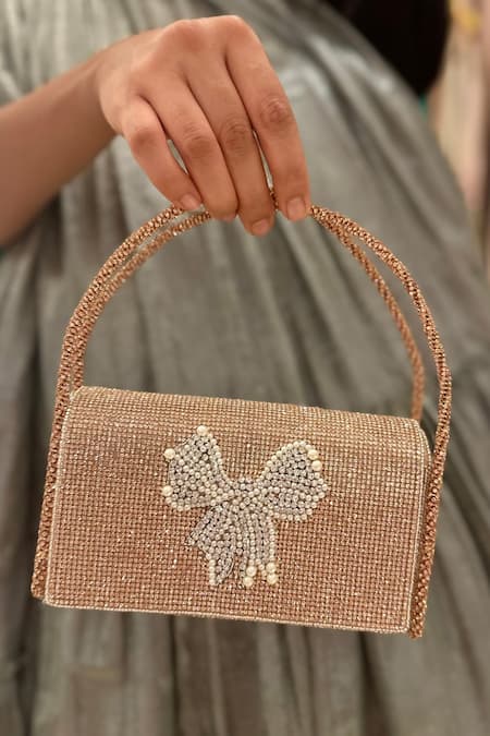 Buy Ozel Rose Gold Crystal Bow Embellished Flap Bag Online at Aza Fashions Buy_Ozel_Rose Gold Crystal Bow Embellished Flap Bag _Online_at_Aza_Fashions