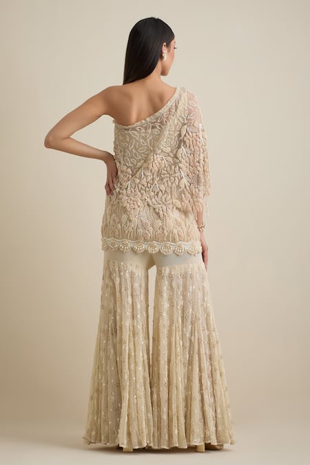 Shop Eeksha Beige Lace, Lycra, Net Pearls, Sequins One Shoulder Embroidered Cape Sharara Set at Aza Fashions Shop_Eeksha_Beige Lace, Lycra, Net Pearls, Sequins One Shoulder Embroidered Cape Sharara Set _at_Aza_Fashions
