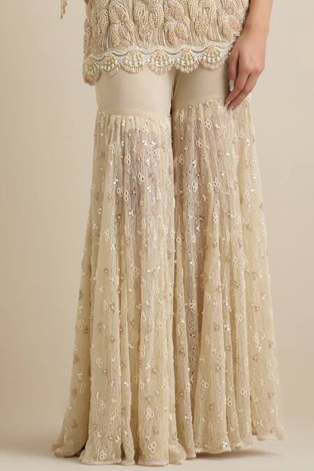 Shop Eeksha Beige Lace, Lycra, Net Pearls, Sequins One Shoulder Embroidered Cape Sharara Set Online at Aza Fashions Shop_Eeksha_Beige Lace, Lycra, Net Pearls, Sequins One Shoulder Embroidered Cape Sharara Set _Online_at_Aza_Fashions