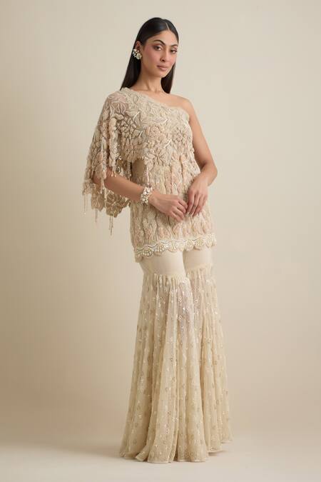 Eeksha Beige Lace, Lycra, Net Pearls, Sequins One Shoulder Embroidered Cape Sharara Set at Aza Fashions Eeksha_Beige Lace, Lycra, Net Pearls, Sequins One Shoulder Embroidered Cape Sharara Set _at_Aza_Fashions