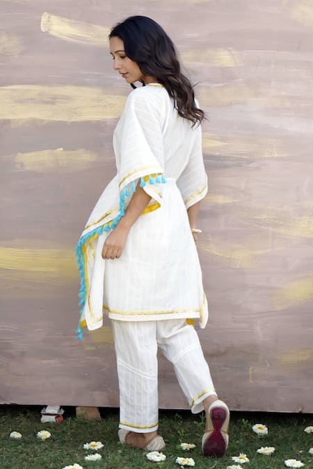 Shop Nero India Ivory Cotton Tassels, Gota Patti Lace Embellished Kaftan Tunic And Pant Set at Aza Fashions Shop_Nero India_Ivory Cotton Tassels, Gota Patti Lace Embellished Kaftan Tunic And Pant Set _at_Aza_Fashions