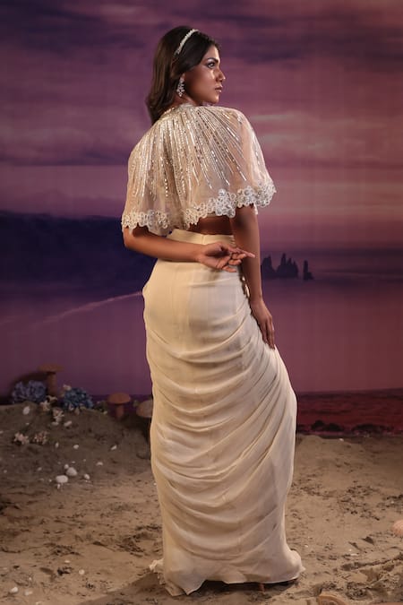Shop COUTURE BY NIHARIKA Ivory Viscose, Georgette, Organza Geometric Embroidered Cape Draped Skirt Set at Aza Fashions Shop_COUTURE BY NIHARIKA_Ivory Viscose, Georgette, Organza Geometric Embroidered Cape Draped Skirt Set _at_Aza_Fashions