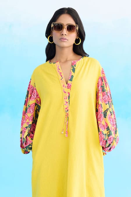 Shop Nikasha Yellow Cotton Tassels Open Neck A-line Rose Print Sleeve Dress at Aza Fashions Shop_Nikasha_Yellow Cotton Tassels Open Neck A-line Rose Print Sleeve Dress _at_Aza_Fashions