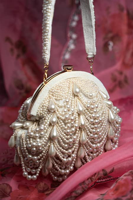 Shop Nayaab By Sonia Off White Pearls Oyster Frame Snowflake Embellished Potli Clutch at Aza Fashions Shop_Nayaab By Sonia_Off White Pearls Oyster Frame Snowflake Embellished Potli Clutch _at_Aza_Fashions