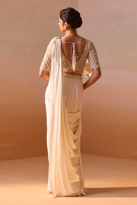 Shop Nitika Gujral Ivory Satin, Net Pearls, Dori Tassel Embellished Pre-draped Saree With Blouse at Aza Fashions Shop_Nitika Gujral_Ivory Satin, Net Pearls, Dori Tassel Embellished Pre-draped Saree With Blouse _at_Aza_Fashions