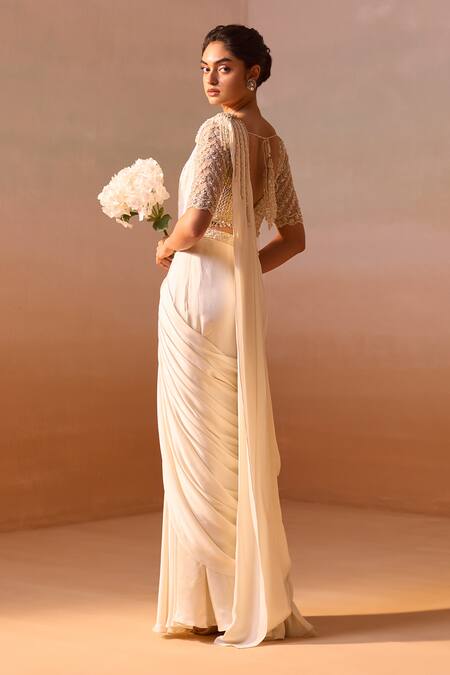 Shop Nitika Gujral Ivory Satin, Net Pearls, Dori Tassel Embellished Pre-draped Saree With Blouse Online at Aza Fashions Shop_Nitika Gujral_Ivory Satin, Net Pearls, Dori Tassel Embellished Pre-draped Saree With Blouse _Online_at_Aza_Fashions