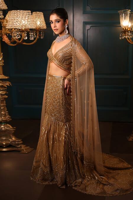 Isa By Dolly Wahal Gold Net Sequins, Crystals V-neck Celeste Fishcut Trail Embroidered Lehenga Set at Aza Fashions Isa By Dolly Wahal_Gold Net Sequins, Crystals V-neck Celeste Fishcut Trail Embroidered Lehenga Set _at_Aza_Fashions