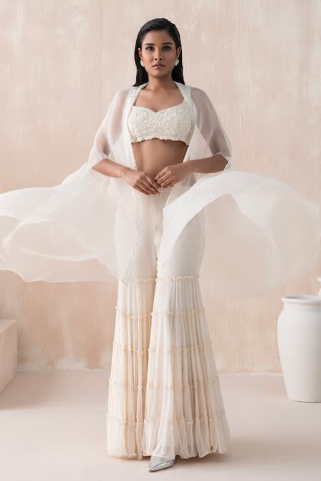 Shop Saisha Ivory Organza, Georgette Sequins, Beads, Asymmetric Cape Tiered Gharara Set at Aza Fashions Shop_Saisha_Ivory Organza, Georgette Sequins, Beads, Asymmetric Cape Tiered Gharara Set _at_Aza_Fashions