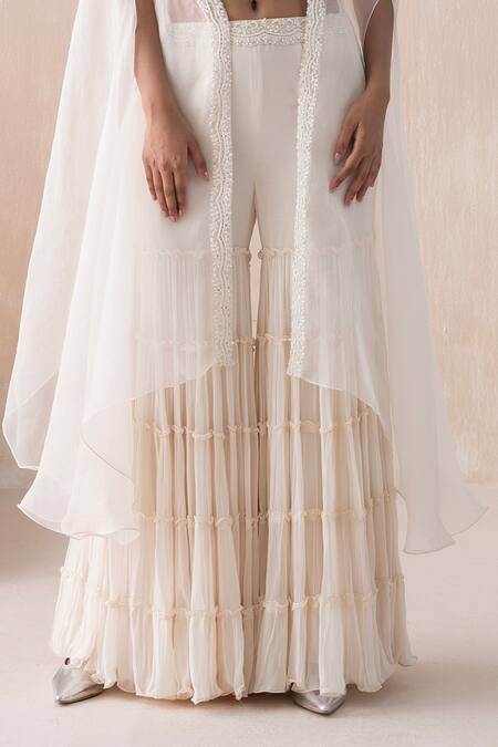 Shop Saisha Ivory Organza, Georgette Sequins, Beads, Asymmetric Cape Tiered Gharara Set Online at Aza Fashions Shop_Saisha_Ivory Organza, Georgette Sequins, Beads, Asymmetric Cape Tiered Gharara Set _Online_at_Aza_Fashions