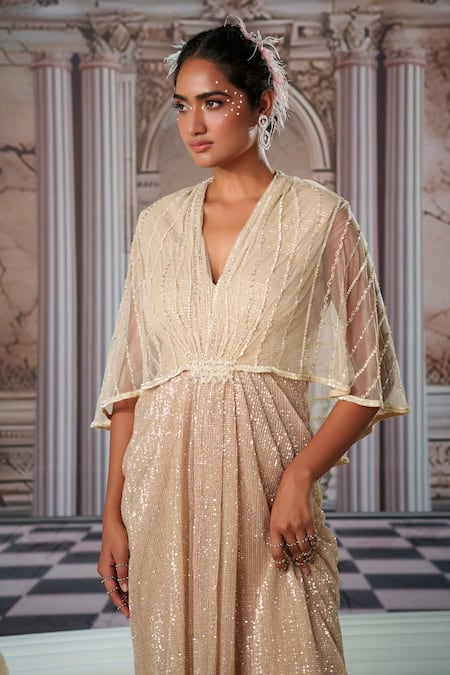 Shop Nidhika Shekhar Beige Net Sequins, Beads V-neck Aphrodite Shimmer Cape Gown Online at Aza Fashions Shop_Nidhika Shekhar_Beige Net Sequins, Beads V-neck Aphrodite Shimmer Cape Gown _Online_at_Aza_Fashions