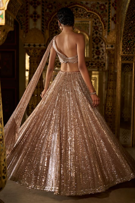 Shop Seema Gujral Rose Gold Net Sequins Asymmetric Embellished Lehenga With Blouse at Aza Fashions Shop_Seema Gujral_Rose Gold Net Sequins Asymmetric Embellished Lehenga With Blouse _at_Aza_Fashions