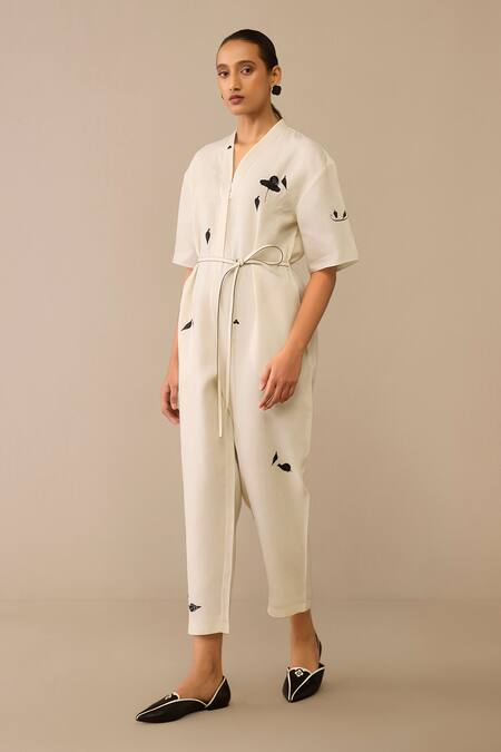 Shop_Ampm_Ivory Linen, Faux Leather Brooches, Embroidery Placed Flower Pattern Jumpsuit_Online_at_Aza_Fashions