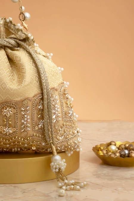Shop_Amyra_Cream Cut Work, Pearls, Tassels, Embroidery Geet Brocade Embellished Potli -_Online_at_Aza_Fashions