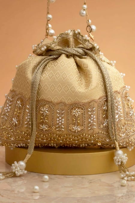 Amyra_Cream Cut Work, Pearls, Tassels, Embroidery Geet Brocade Embellished Potli -_at_Aza_Fashions
