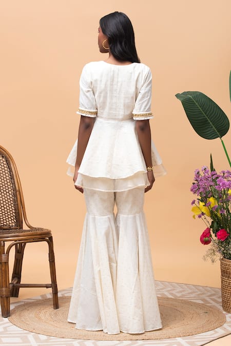 Shop Rishi and Vibhuti Ivory Cotton Zari, Bows V-neck Peplum Top And Gharara Pant Set at Aza Fashions Shop_Rishi and Vibhuti_Ivory Cotton Zari, Bows V-neck Peplum Top And Gharara Pant Set _at_Aza_Fashions
