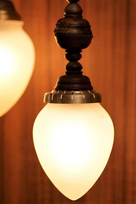 Shop Courtyard White Glass, Metal And Wood Carved Work Kalika Hanging Lamp - Single Pc at Aza Fashions Shop_Courtyard_White Glass, Metal And Wood Carved Work Kalika Hanging Lamp - Single Pc_at_Aza_Fashions