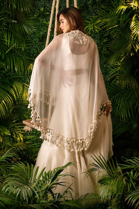 Shop Pallavi Poddar Ivory Satin, Organza, Silk Pearls Rose Cape And Tiered Skirt Set at Aza Fashions Shop_Pallavi Poddar_Ivory Satin, Organza, Silk Pearls Rose Cape And Tiered Skirt Set _at_Aza_Fashions
