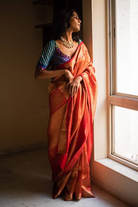 Portrait of beautiful Indian girl in heritage stepwell wearing traditional  Indian red saree, gold jewellery and bangles. Maa Durga agomoni shoot  concept. Traditional woman on stairs with poses photo – Indian ethnicity
