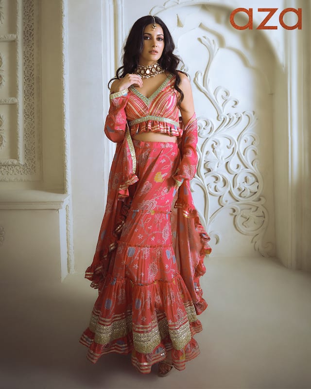 Amyra_Dastur_in_Pink_front-open_asymmetric_jacket_with_floral_print_and_gota_work_frill_border_Paired_with_printed_embroidered_crop_top_and_printed_sharara