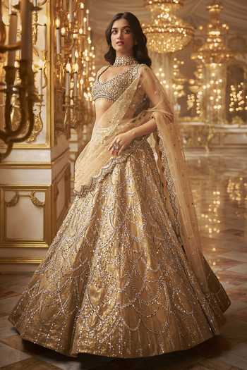 Champagne gold heavy sequin embroidered net lehenga set with scalloped border dupatta.