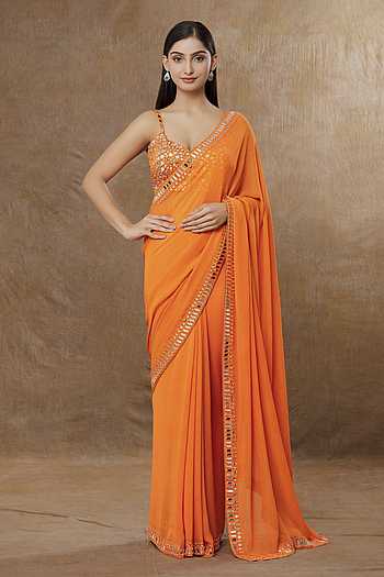Orange draped saree with mirror work choli