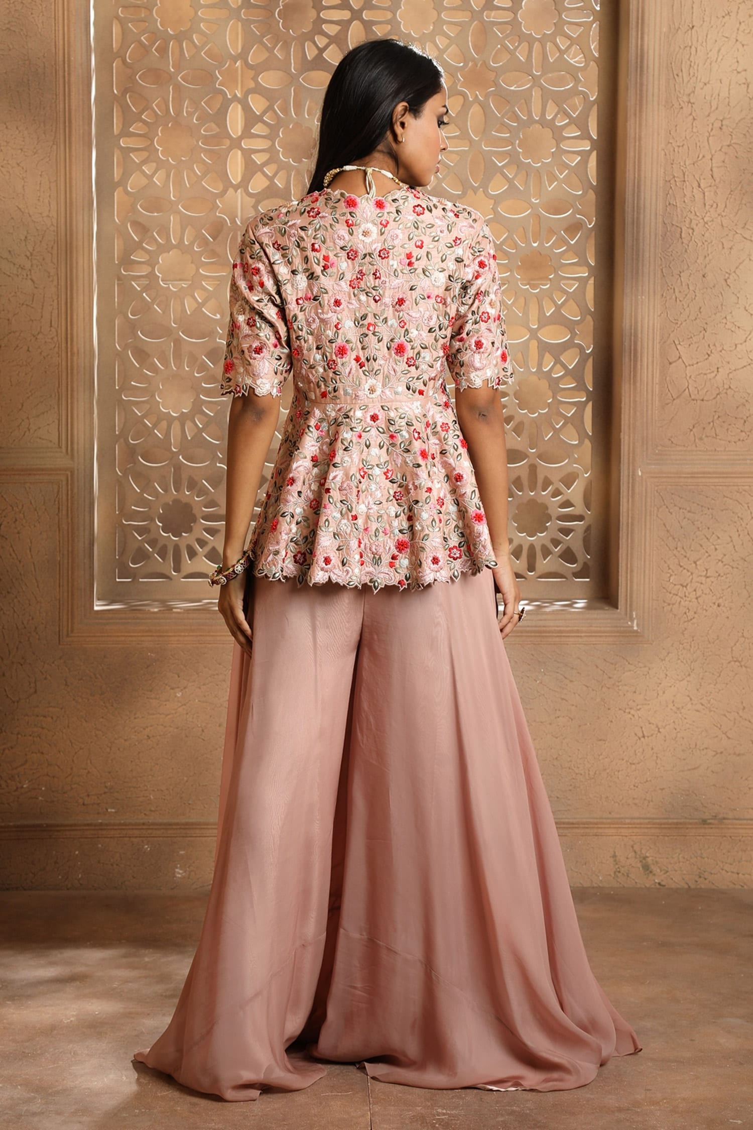 Zahra Ahmad - Blush pink printed lawn pleated peplum top with frilled umbrella  sleeves, embellished laces on bodice and gold lace around flare and sleeves.  Beige cotton plain pleated gharara with silver